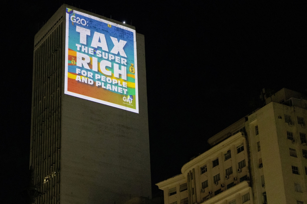 Climate activists from the Glasgow Actions team project a message with an appeal for the taxation of the super-rich on a building during the G20 Summit in Rio de Janeiro, Brazil November 18, 2024. — Reuters pic