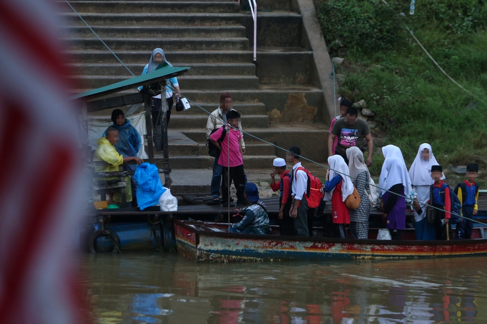 School students use an illegal route on a boat to cross the Malaysia-Thailand border to start the school session November 19, 2024. — Bernama pic