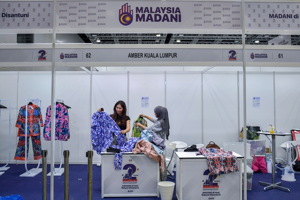 Workers prepare registration counters at the MADANI Government's Two-Year Program (2TM) and the 2024 National Convention on Public Service Reform at the Kuala Lumpur Convention Centre on Nov 21, 2024. — Bernama pic