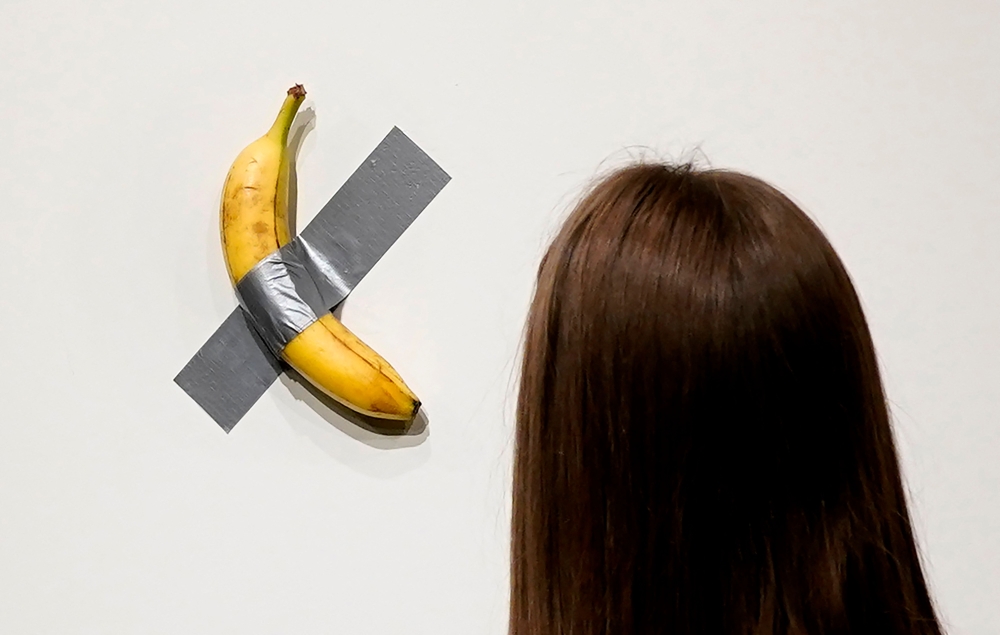 People look at Italian visual artist Maurizio Cattelan's duct-taped Banana entitled 