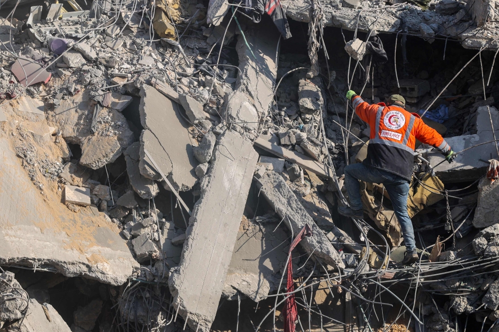 A Palestinian rescuer checks the rubble of a building in the aftermath of an Israeli strike south of Gaza City. — AFP pic