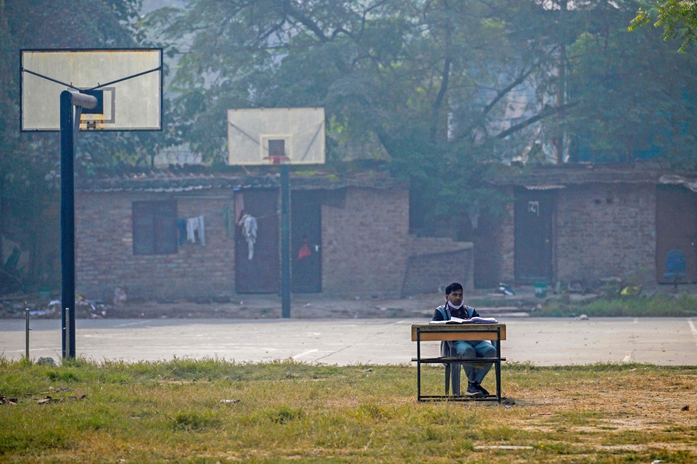 A school teacher conducts an online class near a basketball court at Swami Sivananda Memorial Institute in New Delhi on November 22, 2024. — AFP pic