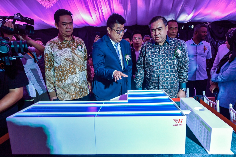 Transport Minister Anthony Loke Siew Fook (right) listens to a briefing on the design of a building to be constructed from Golog CEO Ivan Chin Wen Hao (centre) during the groundbreaking ceremony for the Golog Regional Halal Frozen Smart Distribution Centre (SMART RHDC) in Bandar Enstek. Nov 23, 2024. — Bernama pic