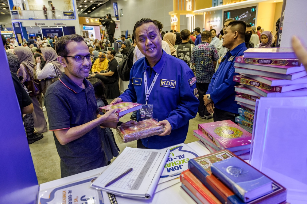 Visitors exchange old Quran at Home Ministry's booth during the Madani Government's two-year anniversary event at the Kuala Lumpur Convention Centre. November 23. 2024. — Picture by Firdaus Latif