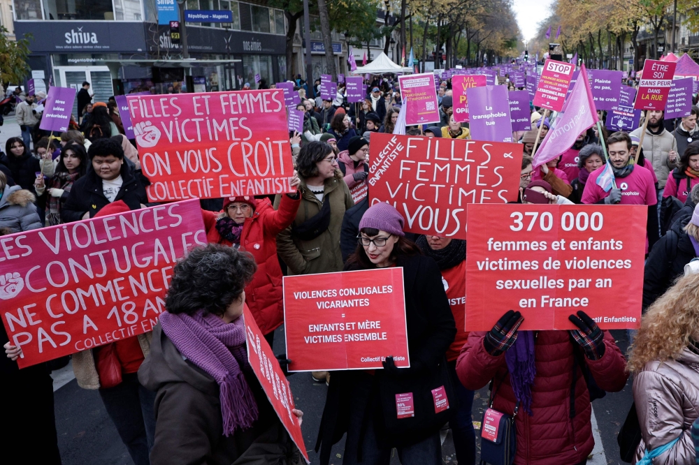 Demonstrators hold placards reading “conjugal violences don’t start at 18 years old” (left), “women and girls victims we believe you, collective Enfantiste”, “vicarious conjugal violences equals mother and children victims together” and “370 000 women and children victims of sexual violences per year in France” as they walk during a protest to condemn violence against women in Paris on November 23, 2024. — AFP pic
