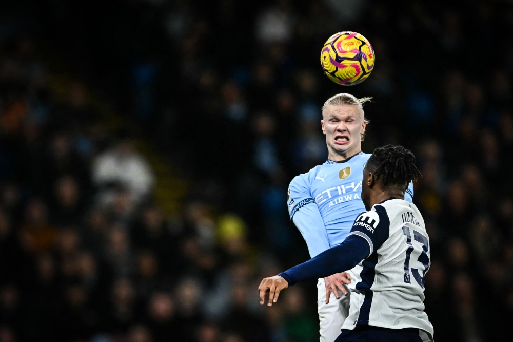 Manchester City’s Norwegian striker #09 Erling Haaland (back) heads the ball as he fights for it with Tottenham Hotspur’s Italian defender #13 Destiny Udogie (front) during the English Premier League football match at the Etihad Stadium in Manchester, north west England on November 23, 2024. — AFP pic