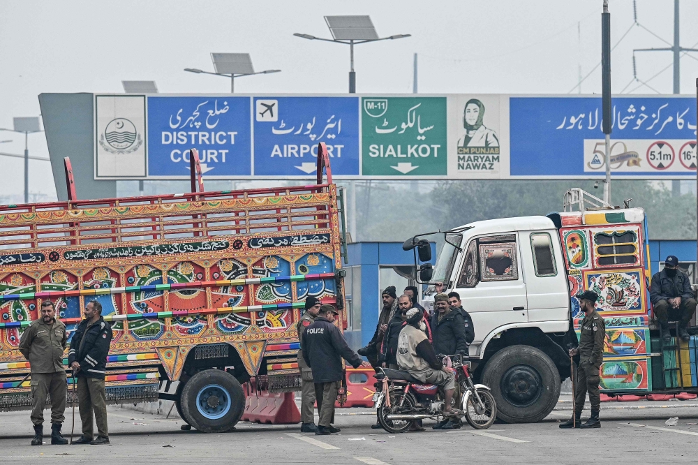 Police personnel stand guard at a closed road before a protest by supporters of former Prime Minister Imran Khan’s Pakistan Tehreek-e-Insaf (PTI) party for Khan’s release in Lahore on November 24, 2024. — AFP pic