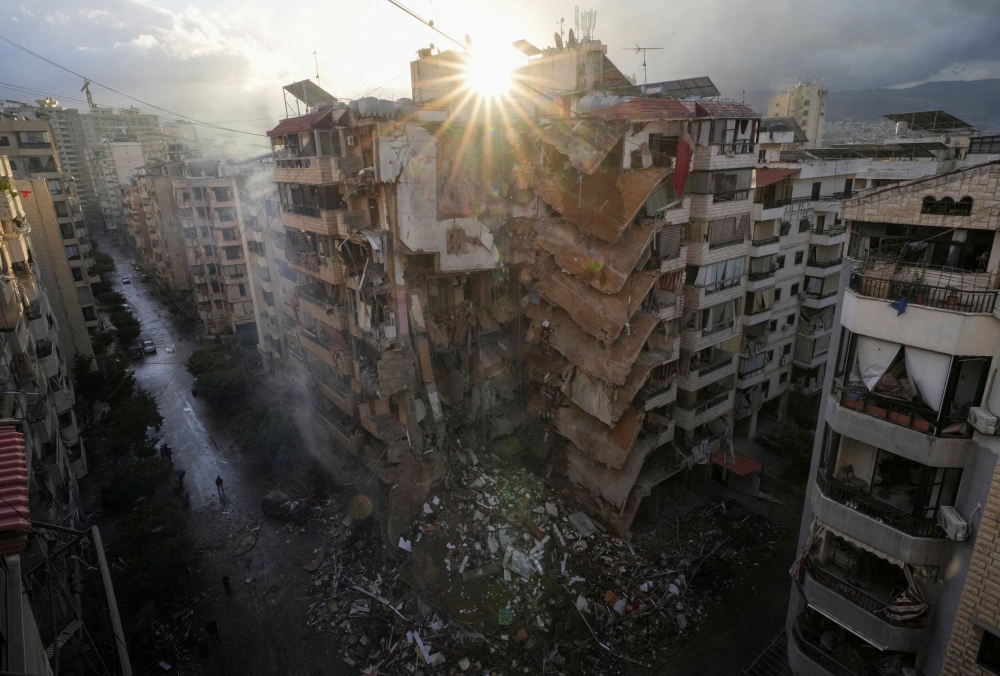 People walk past damaged buildings, in the aftermath of Israeli strikes on Beirut's southern suburbs, amid the ongoing hostilities between Hezbollah and Israeli forces, Lebanon November 25, 2024. — Reuters pic