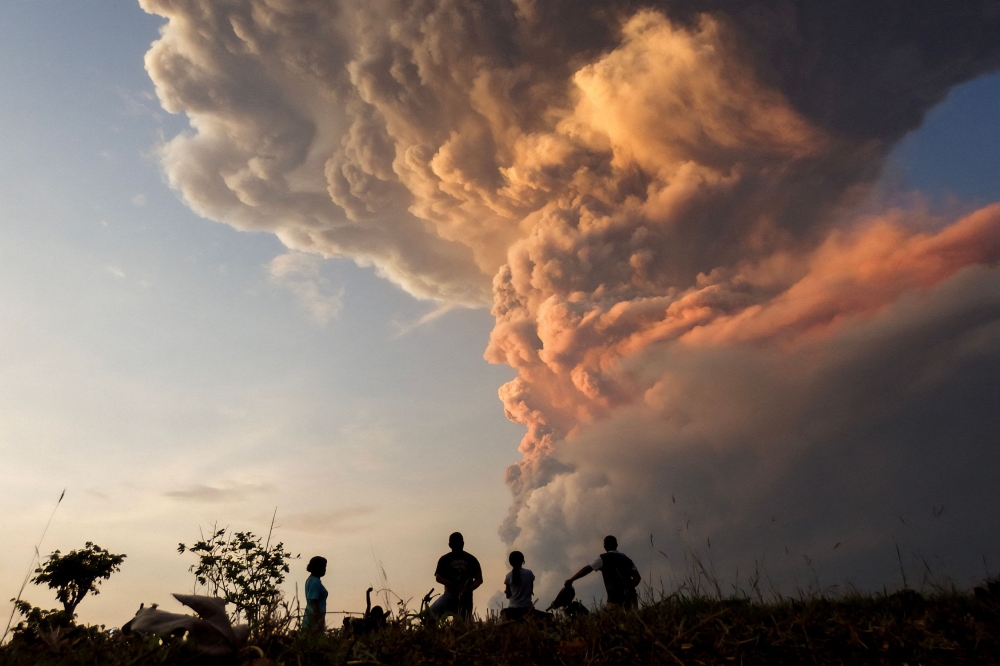 File picture of residents watch the ash cloud from the eruption of Mount Lewotobi Laki Laki from Lewolaga village in East Flores November 9, 2024. Another volcano in Indonesia, Mount Dukono, situated in the eastern North Maluku province, erupted today. — AFP pic
