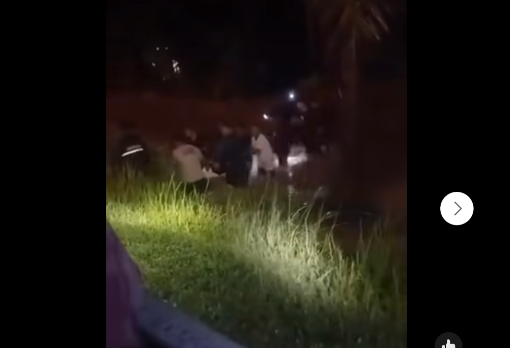 Fire Dept personnel carry the body of Tuan Mohd Zakaria Tuan Ismail, who was found entangled in a tree by the riverbank near his home, November 27, 2024 in this screengrab from social media. 