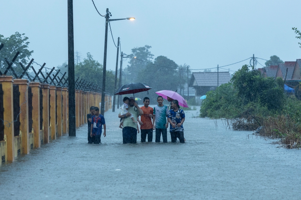 Residents of Taman Sri Mas pagi walk through floodwaters while on their way to a flood relief centre in Pasir Mas, Kelantan, November 27, 2024. –– Bernama pic
