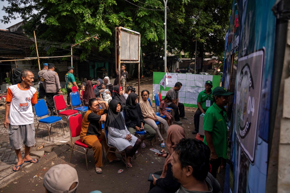 People queue to cast their votes during the simultaneous regional elections at a polling station in Surabaya on November 27, 2024. Indonesians vote to pick local leaders in the country's biggest simultaneous regional election, in which President Prabowo Subianto seeks to consolidate his party's gains. — AFP pic