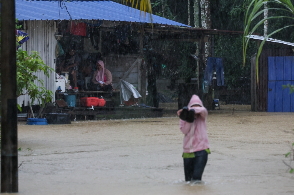 Residents sit in front of their flood-affected homes in Kampung Permaisuri, Terengganu, November 28, 2024. –– Bernama pic 