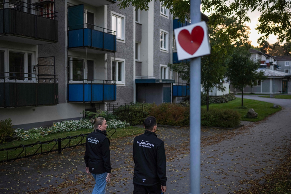 Swedish social workers Julia Rydberg (left) and Abbe Abid patrol the neighbourhood of Baronbackarna in Örebro on September 23, 2024 as the country struggles to rein in surging gang shootings and bombings, linked to score-settling and battles to control the illicit drug market in the country of 10.5 million people. — AFP pic