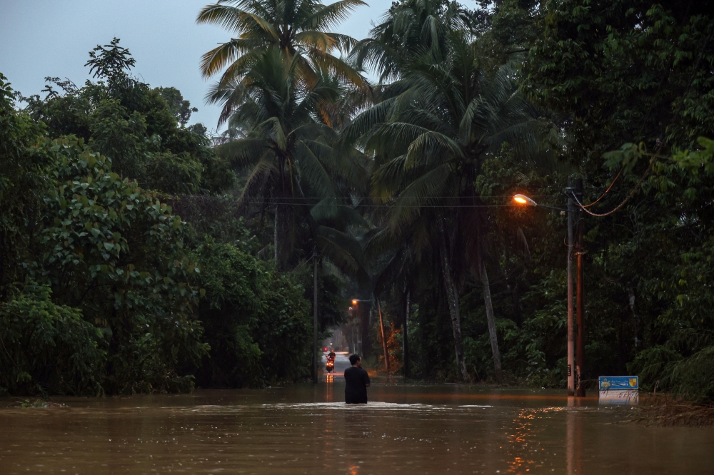 A resident wades through floodwaters to check on the condition of his home at Blok Tanah Merah Jeli in Kelantan, November 28, 2024. –– Bernama pic