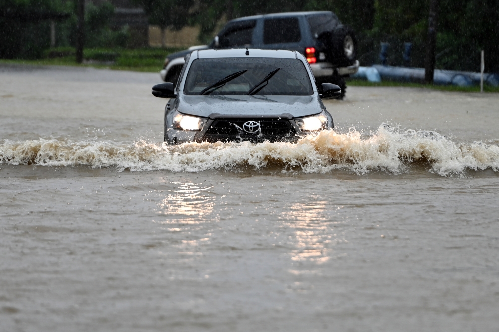 A vehicle navigates through floodwaters on the main road from Kuala Berang to Kuala Terengganu, which was inundated following heavy rainfall, as observed in Kampung Batu 24, November 28, 2024. –– Bernama pic 