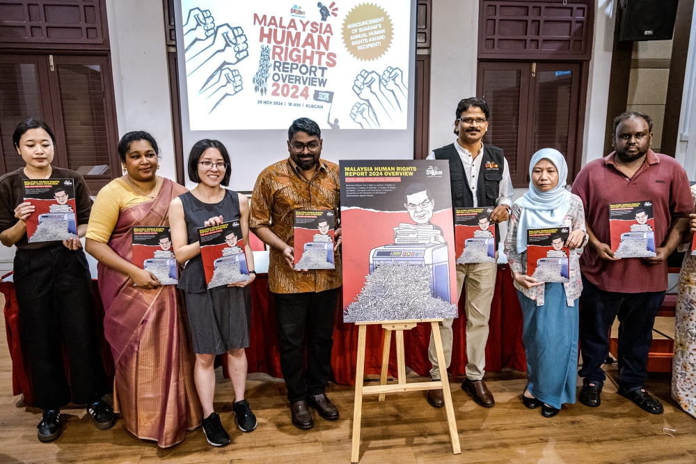 Members of Suaram pose for a group photo during the launch of the Suaram Malaysia Human Rights Report Overview 2024 at the Kuala Lumpur and Selangor Chinese Assembly Hall on November 29, 2024. –– Picture by Firdaus Latif