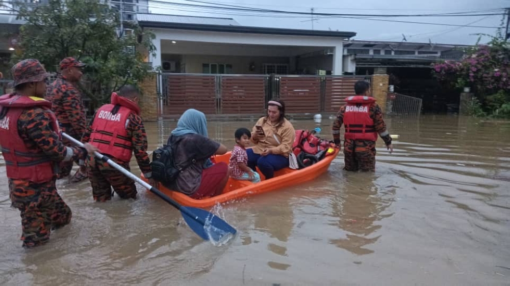 One of the families being transported to safety in Kolombong. — The Borneo Post pic