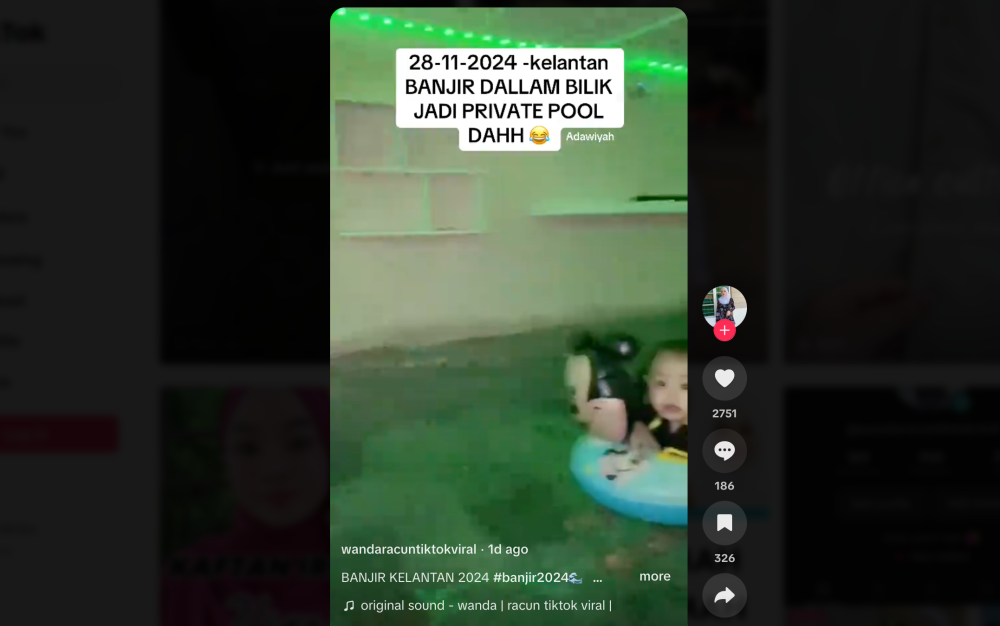 A child wearing a ring float paddles in a flooded house basement room in Kelantan turned into a private pool on November 28, 2024. — Screenshot from TikTok/Wanda