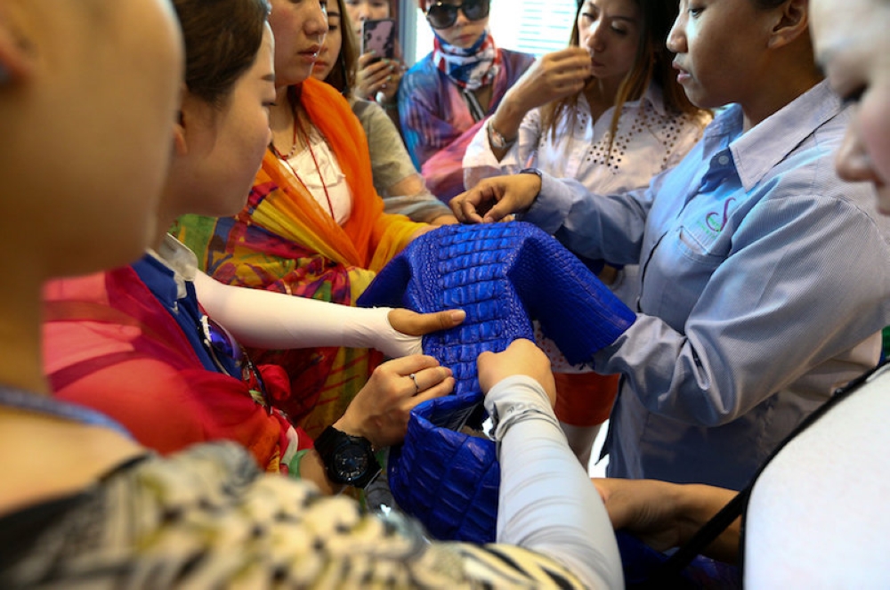 People touch a dyed crocodile skin at the Sriracha Crocodile Farm in Chonburi province, Thailand on June 20, 2017. — Reuters file pic