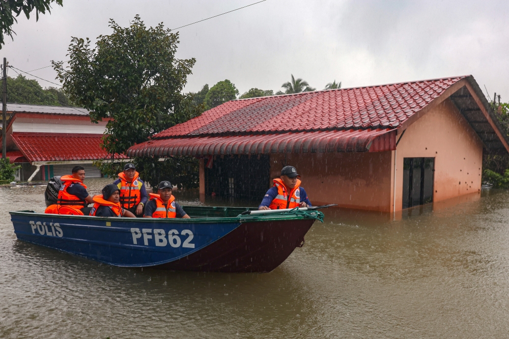 Police officers monitor the flood situation following continuous rainfall over the past few days in Kampung Lati, Pasir Mas November 29, 2024. — Bernama pic