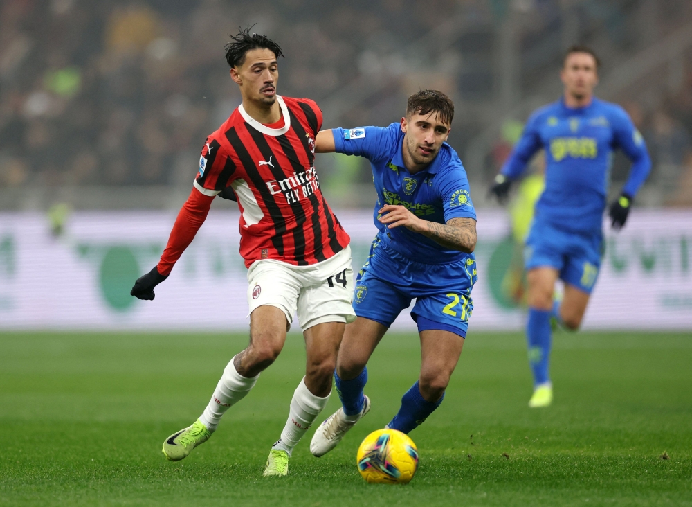 AC Milan’s Tijjani Reijnders in action with Empoli’s Mattia Viti. — Reuters pic