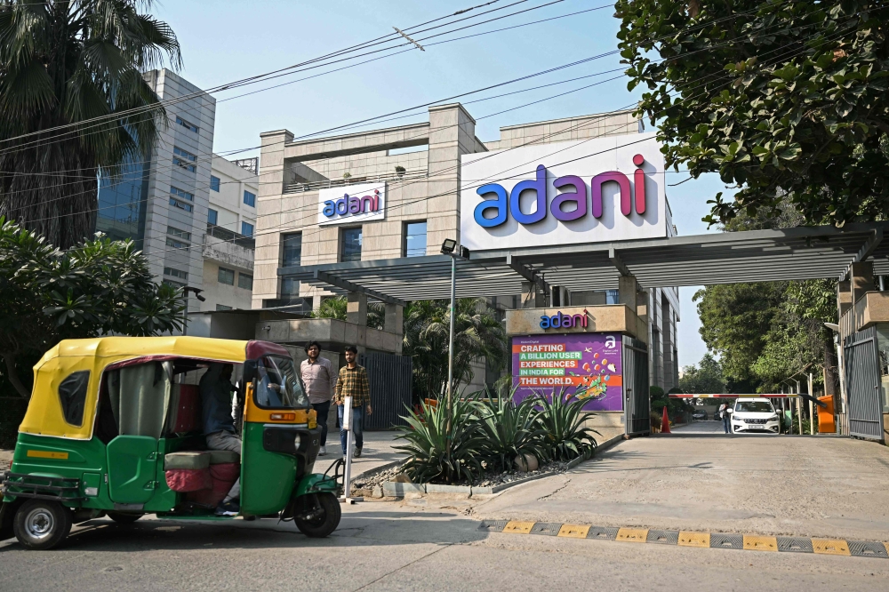 Pedestrians walk past the ‘Adani House’ corporate building in Gurgaon on November 27, 2024. India’s Adani Group conglomerate said on November 27 it had lost almost US$55 billion in a stock market rout since US prosecutors last week accused its founder and other officials of fraud. — AFP pic