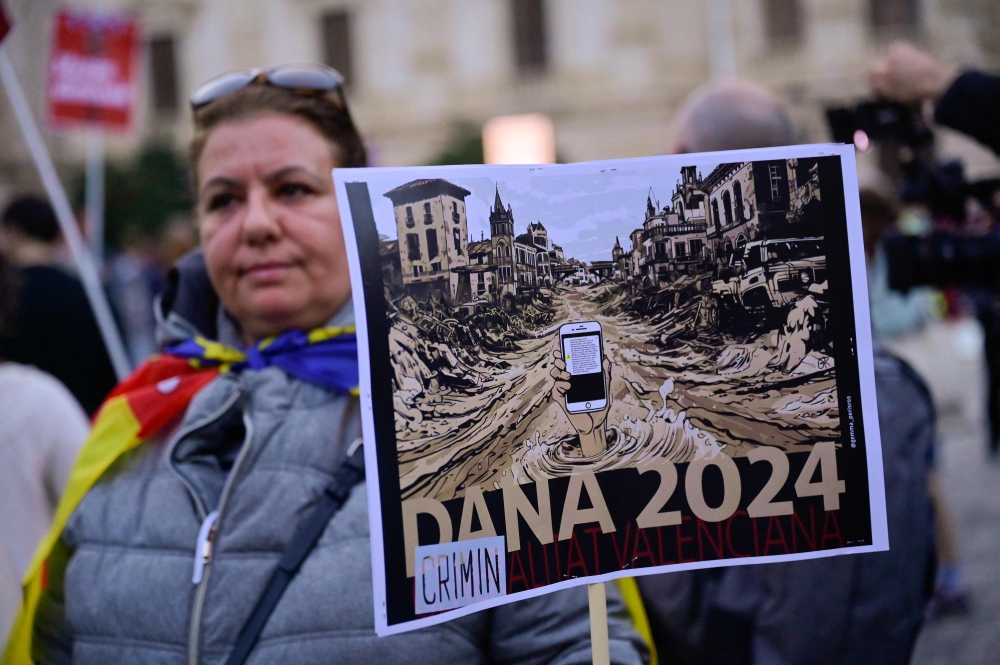 People carry banners during a demonstration to protest the regional government’s response and call for the resignation of Valencia regional president Carlos Mazon, a month after devastating floods in Valencia, eastern Spain, on November 30, 2024. — AFP pic