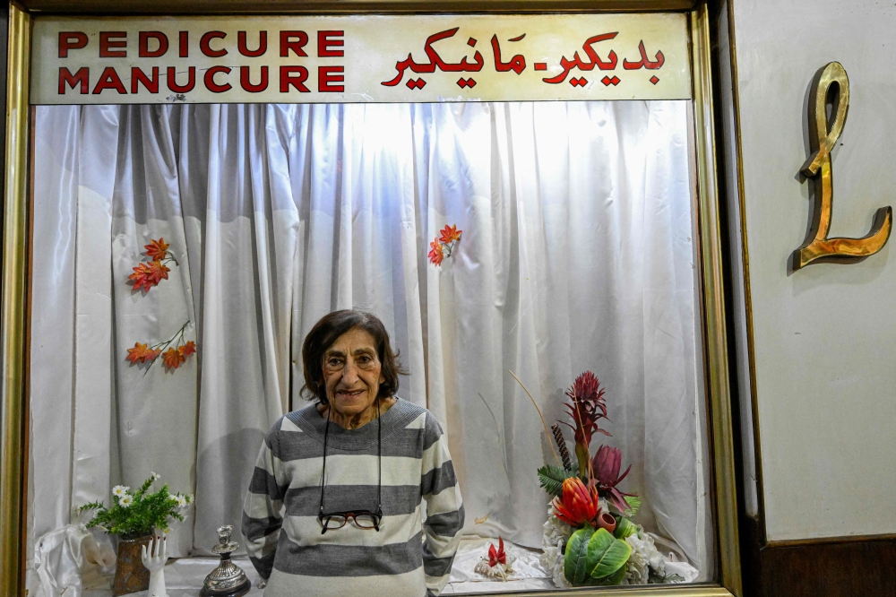 Madam Lucie, an 88-year-old manicurist expert, poses for a picture at her manicure shop in downtown Cairo on November 18, 2024. Nestled in a hidden alley off a bustling thoroughfare in the heart of the Egyptian capital sits an unassuming little manicure shop concealing a historic legacy. — AFP pic
