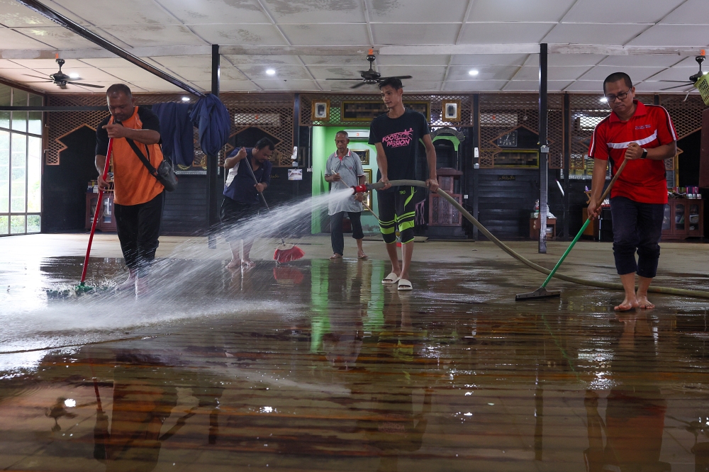 Members of the Pasir Simpul Mosque congregation in Hulu Terengganu clean the village mosque, which was also affected by the floods in Kuala Berang, Terengganu, December 2, 2024. — Bernama pic 