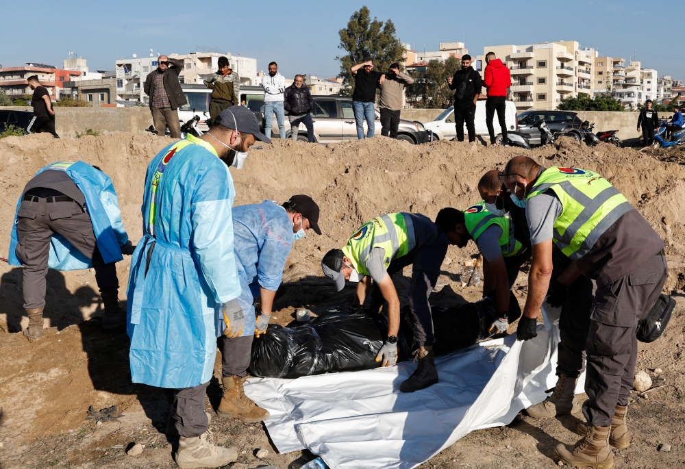 Members of civil defence remove bodies of people killed during hostilities between Israel and Hezbollah, including fighters, from a temporary cemetery to be taken for burial in their home town and villages, after a ceasefire between the two, in Tyre, southern Lebanon, December 2, 2024. — Reuters pic