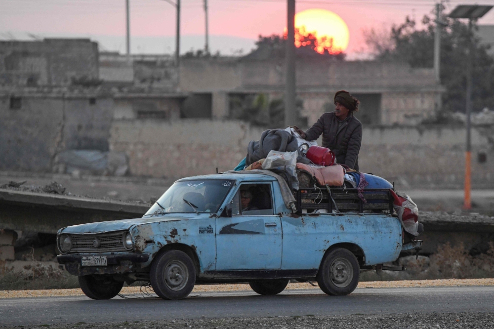 Displaced Syrian Kurds drive a vehicle loaded with belongings on the Aleppo-Raqqa highway to flee areas on the outskirts of the northern city of Aleppo which were formerly controlled by the Kurdish-led Syrian Democratic Forces (SDF), after they were seized by Islamist-led rebels on December 2, 2024. — AFP pic