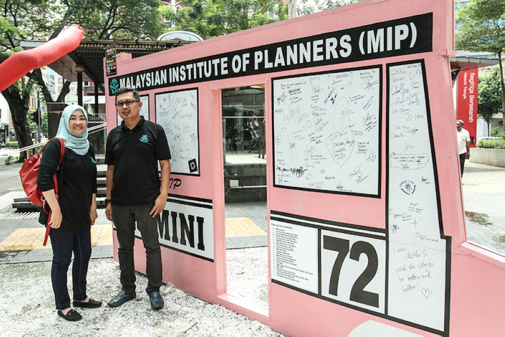 Juwairiyah Ho and Abdul Hamid Akub stand next to the replica of the iconic pink mini bus that used to ply the streets of Kuala Lumpur. — Picture by Miera Zulyana