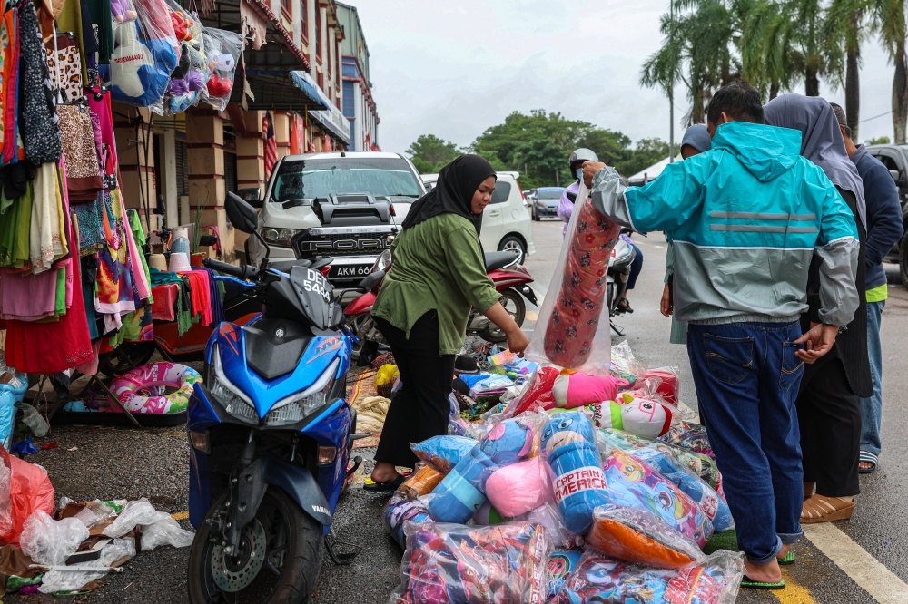 People buying household items during a public auction that priced items as low as RM5, held at the Rantai Panjang Duty Free Zone in Kelantan to aid residents displaced by the ongoing year end floods that started in November 2024. — Bernama pic