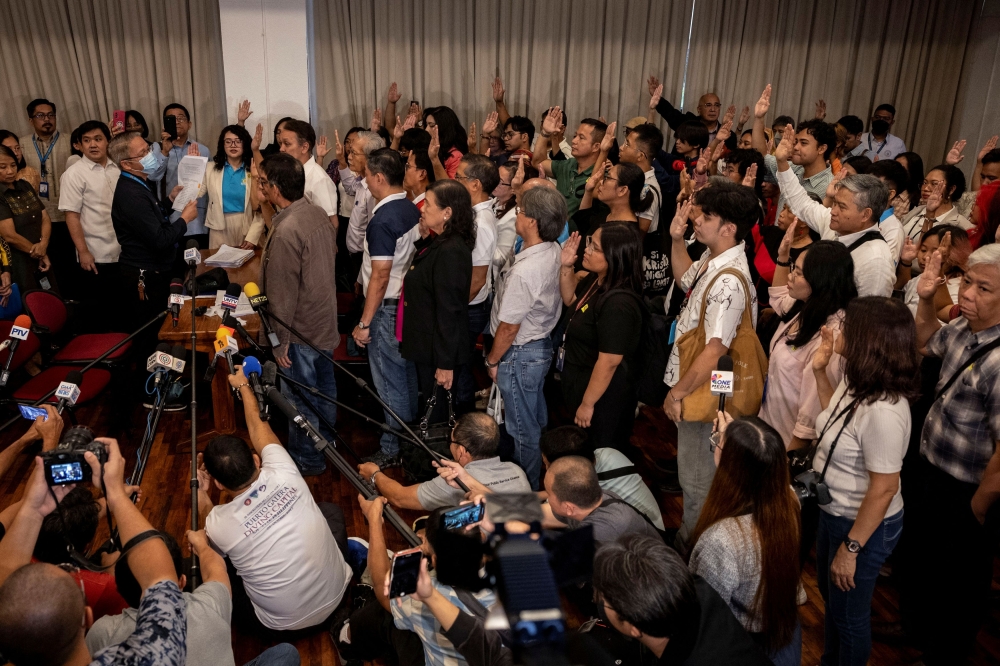 Left-wing activists and former government officials take an oath before a notary public, before filing their impeachment complaint against Vice President Sara Duterte at the House of Representatives in Quezon City, Philippines, December 4, 2024. — Reuters pic 
