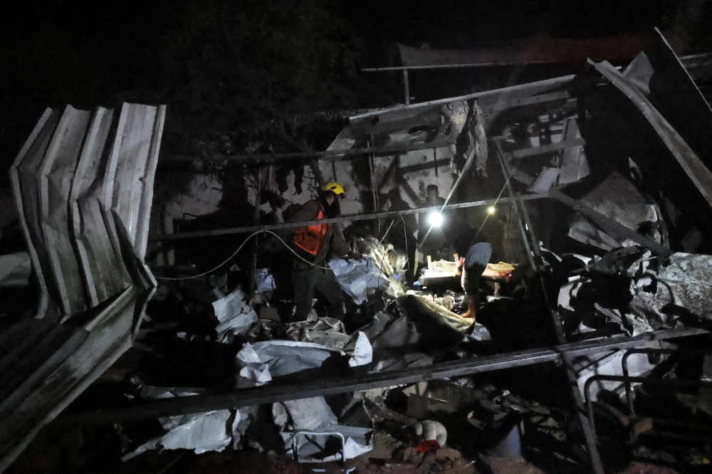 A rescuer sifts through charred debris after an Israeli strike hit a makeshift camp for displaced Palestinians, in Mawasi Khan Yunis in the southern Gaza Strip on December 4, 2024, amid the ongoing war between Israel and the Hamas group. — AFP pic