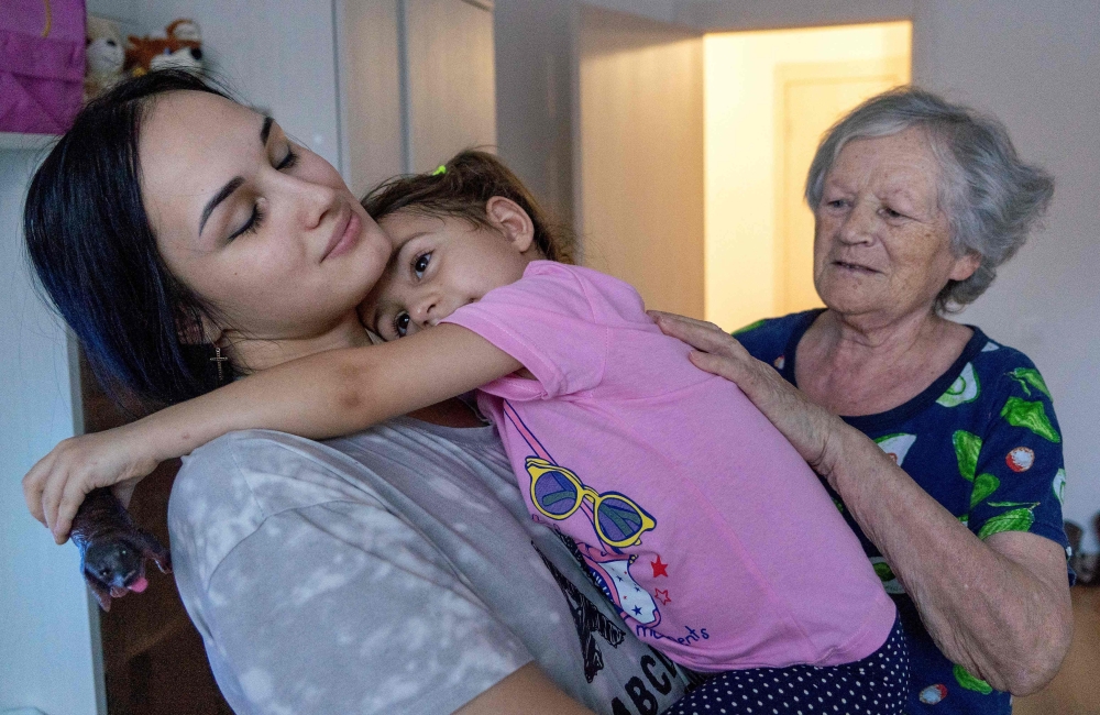 Anastasia Gridina (left), 21-year-old resident of the Kursk region temporarily living in Moscow, holds her three-year-old daughter Darina Gridina, as Tatyana Gridina, 78, Darina's grand-mother looks at them in a Moscow suburb on November 25, 2024, just a week after they were reunited following Ukraine’s army surprise incursion last August. — AFP pic 