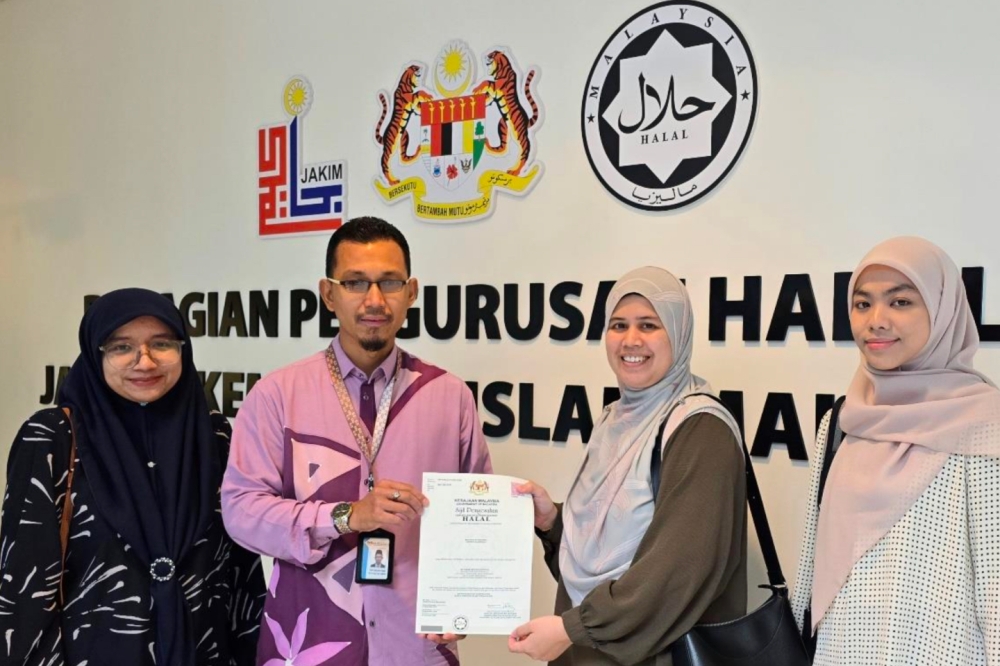 Representatives from Bungkus Kaw Kaw receiving the halal certificate from Malaysian Islamic Development Department (Jakim). — Picture courtesy of Bungkus Kaw Kaw