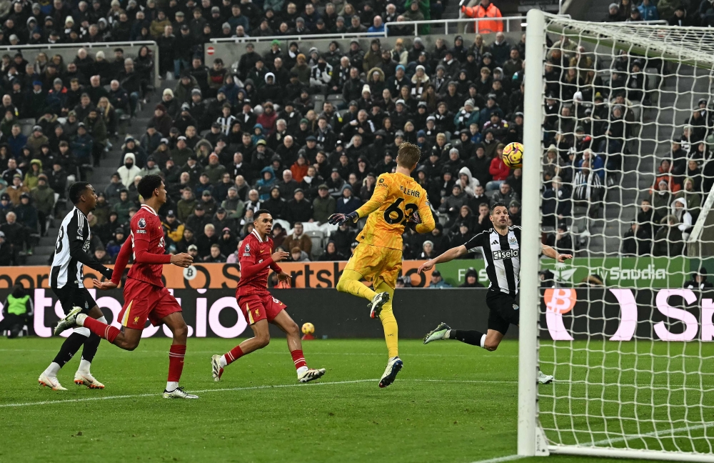 Newcastle United's Swiss defender #05 Fabian Schar (right) scores the team's third goal during the English Premier League football match between Newcastle United and Liverpool at St James' Park in Newcastle-upon-Tyne December 4, 2024. — AFP pic