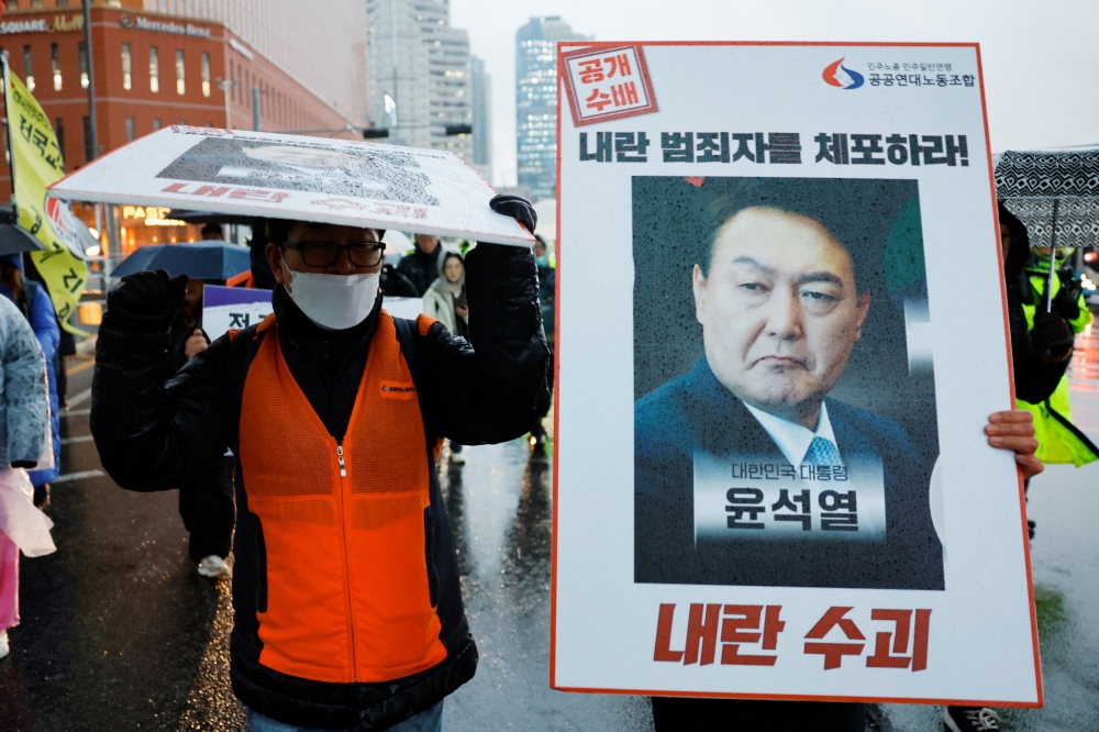 A protester holds a placard during a rally to condemn South Korean President Yoon Suk-yeol's surprise declarations of the failed martial law and to call for his resignation in Seoul, South Korea, December 5, 2024. — Reuters pic