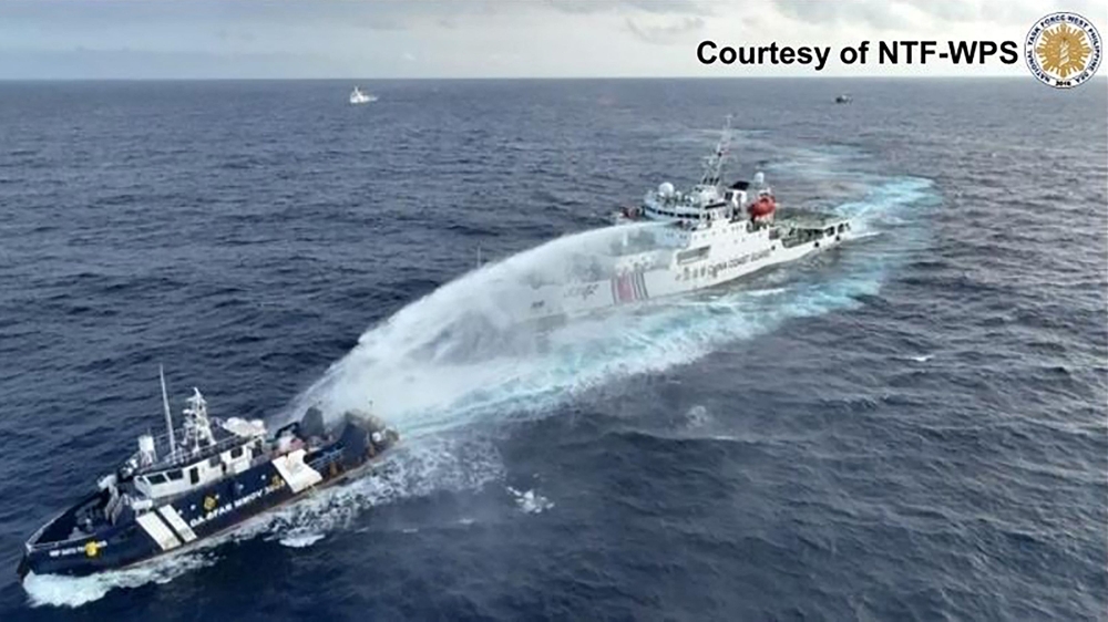 This handout taken and released on December 4, 2024 by the National Task Force for the West Philippine Sea (NTF-WPS) shows a China Coast Guard ship (right) deploying water cannon at the Phillipine Bureau of Fisheries and Aquatic Resources (BFAR) vessel BRP Datu Pagbuaya (left) near Scarborough Shoal in disputed waters of the South China Sea. The Philippines said the China Coast Guard fired water cannon December 4 on a government vessel during a maritime patrol near the disputed Scarborough Shoal. — National Task Force for the West Philippine Sea handout pic via AFP 