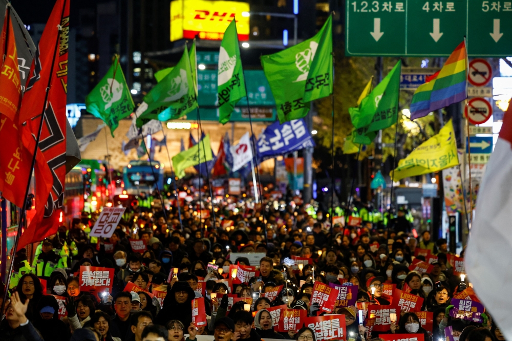 People protest during a candlelight vigil to condemn South Korean President Yoon Suk Yeol's surprise declarations of the failed martial law and to call for his resignation in Seoul, South Korea, December 5, 2024. — Reuters pic