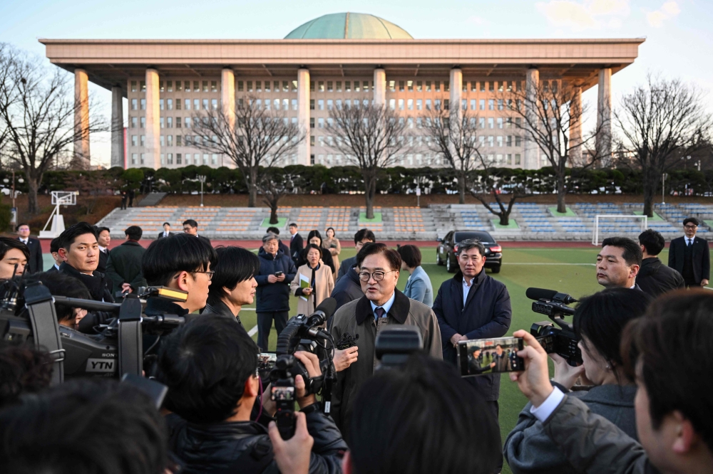 National Assembly Speaker Woo Won-shik (C) speaks to the media outside the National Assembly in Seoul, South Korea on December 6, 2024, as he surveys the compound to look at vehicles parked on the grounds to prevent helicopters from landing due to concerns around another possible imposition of martial law. — AFP pic