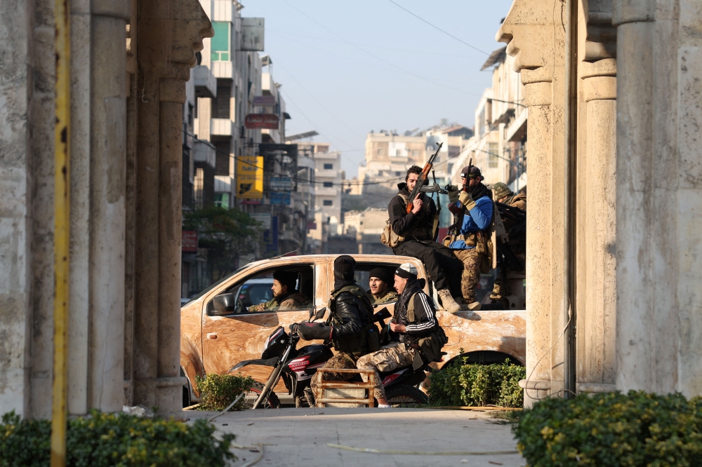Anti-government fighters patrol the streets of Hama after they captured the central Syrian city, on December 6, 2024. — AFP pic