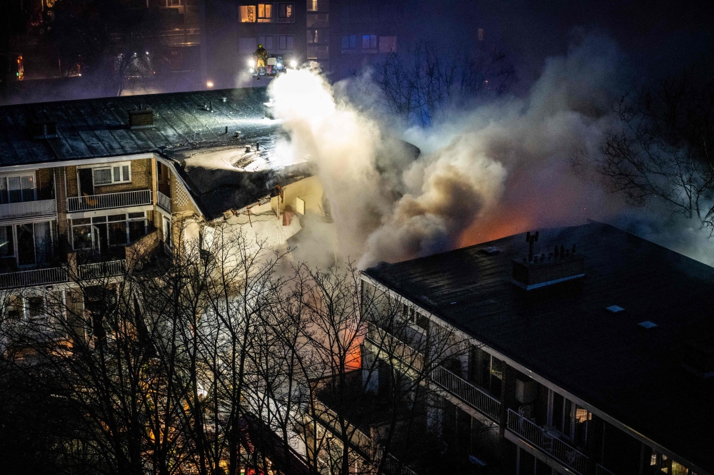 A three-storey apartment block in The Hague partially collapsed today after a fire and explosion, firefighters said, with first responders searching for people under the rubble. — AFP pic