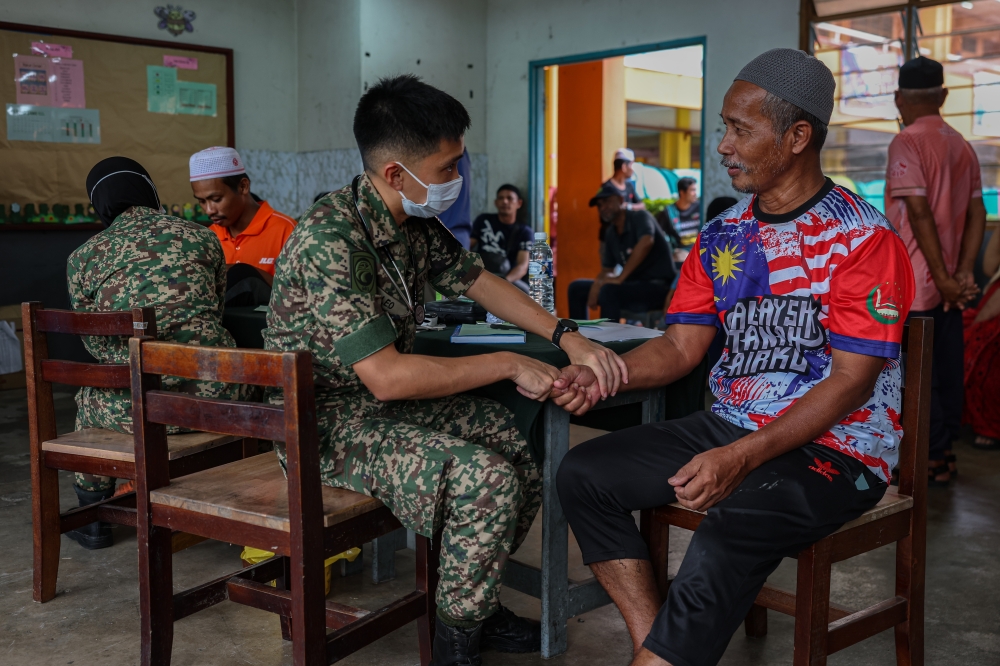 Malaysian Armed Forces personnel provide medical treatment to flood victims at a temporary evacuation centre in Rantau Panjang, Kelantan, on Dec 6, 2024. — Bernama pic