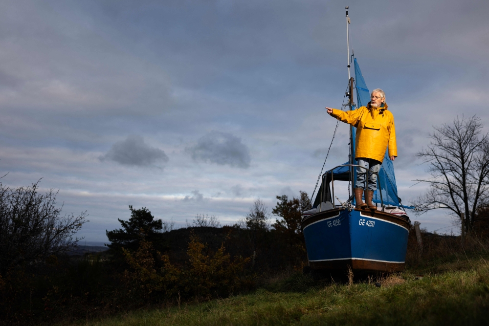 Frenchman Bernard Poitau poses on his boat ‘Anticylone’ as he takes part in the Vendee Globe, the solo non-stop round the world yacht race, on the Virtual Regatta sailing race simulator, spending 22 hours a day on a boat on slipways in his garden to raise charity funds in Saint-Julien-Molin-Molette, central-eastern France December 3, 2024. The tenth edition of Vendee Globe, which takes place every four years, sailed out from Les Sables-d'Olonne in western France on November 10 with 40 skippers embarking on a 24,300 nautical mile course which will take roughly three months to complete. — AFP pic