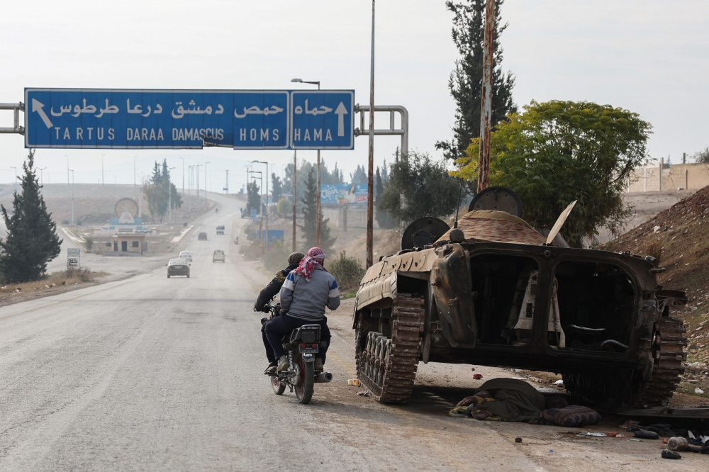 A military vehicle belonging to the Syrian regime forces is pictured abandoned on the side of a road in the Hama. — AFP pic