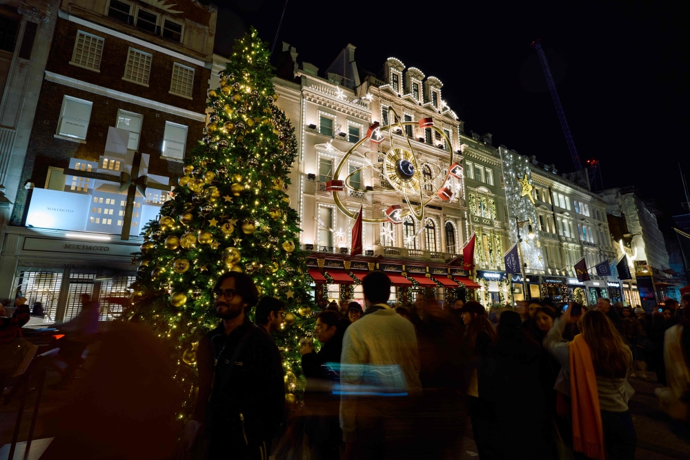 Members of the public look at the annual Christmas lights on Old Bond Street in central London December 6, 2024. — AFP pic
