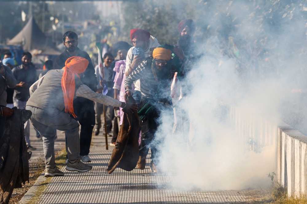 Farmers react after a tear gas shell was launched towards them, as farmers march towards New Delhi to press for better crop prices promised to them in 2021, at the Shambhu barrier, a border crossing between Punjab and Haryana states, India, December 6, 2024. — Reuters pic  